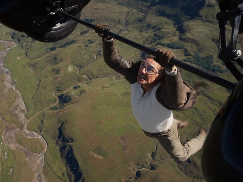 Tom Cruise hænger og dingler fra et fly i fuld fart i den nye Mission Impossible-film.
