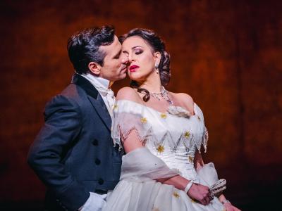 De to hovedpersoner fra La Traviata i en hed omfavnelse.